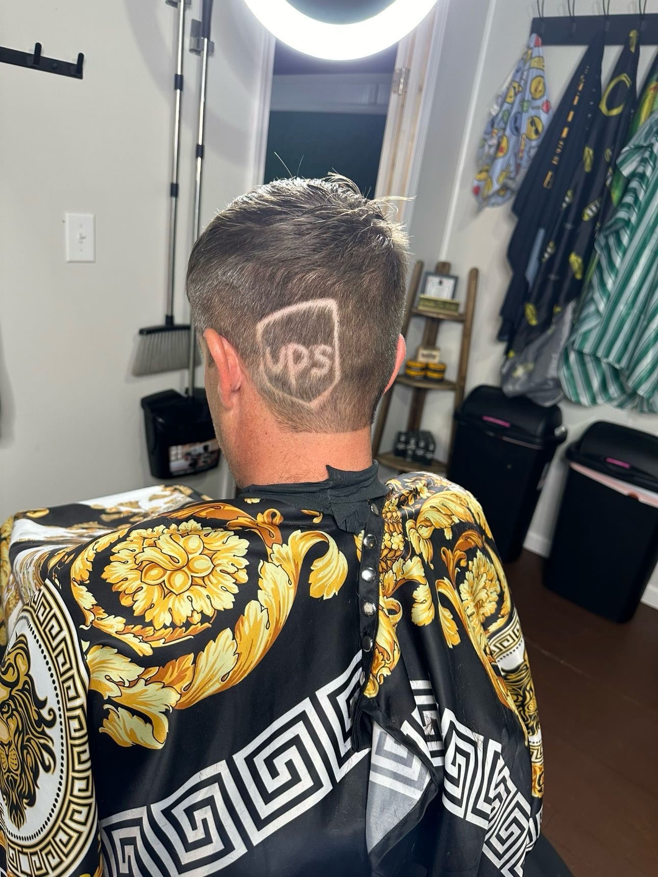 Precision skin fade haircut with UPS logo design by Taylor Corbett